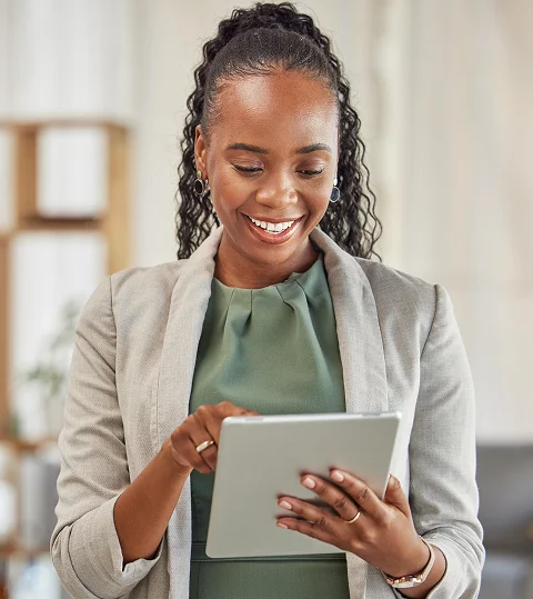 Smiling businesswoman using a tablet in an office