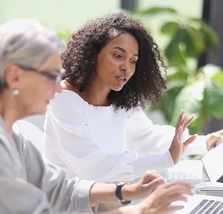 Two women reviewing information together on a laptop