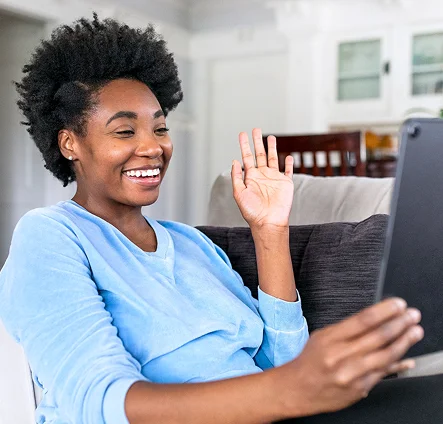 Woman waving during a video call on a tablet