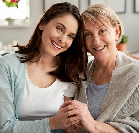 Two smiling women sitting together and holding hands